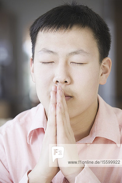 Close-up of a teenage boy praying