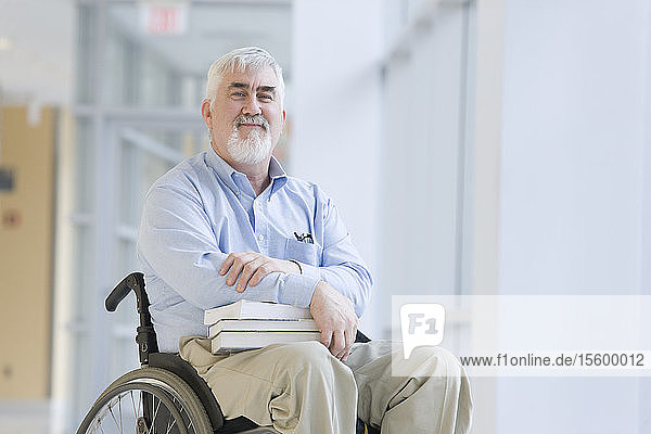 Porträt eines Professors mit Muskeldystrophie  der in einem Rollstuhl sitzt