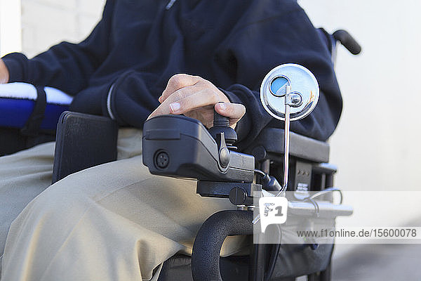 Mann mit Rückenmarksverletzung benutzt seinen motorisierten Rollstuhl