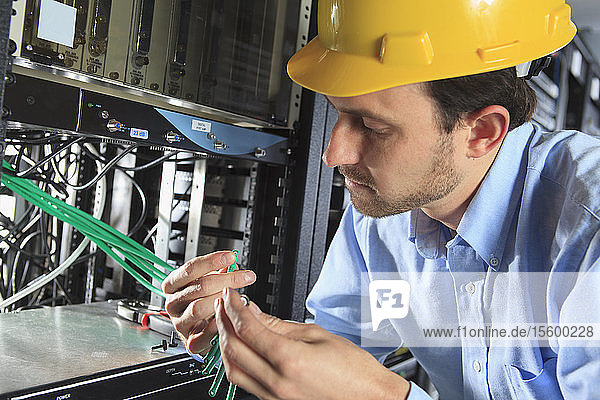 Network engineer examining cable for termination