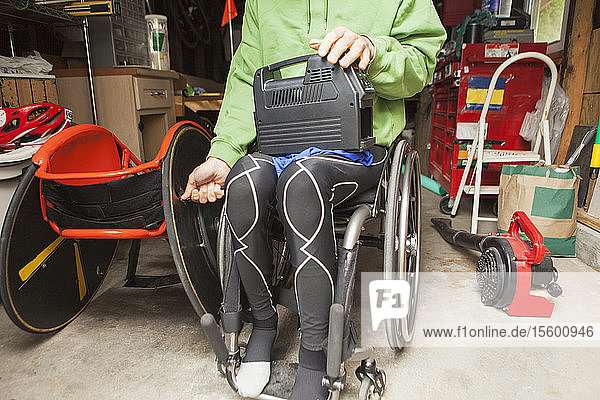 Rollstuhlfahrer mit Querschnittslähmung bereitet Rollstuhlreifen für ein Rennen vor