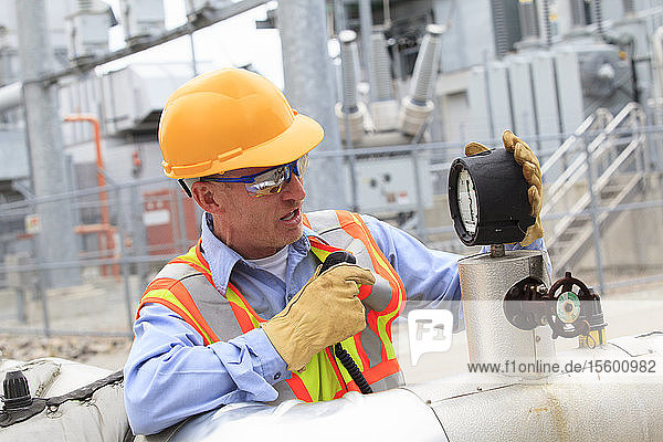 Electrical engineer examining pressure sensor at an electric power plant