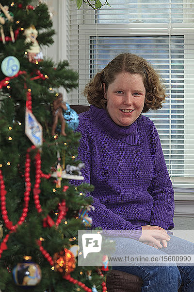Junge Frau mit Autismus erfreut sich am Weihnachtsbaum
