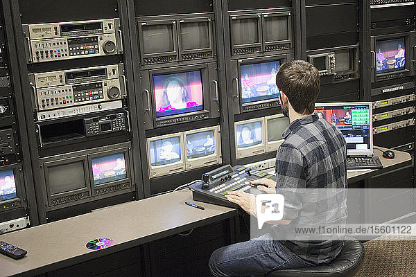 Video editor at work in a TV editing control room at a Cable TV Studio