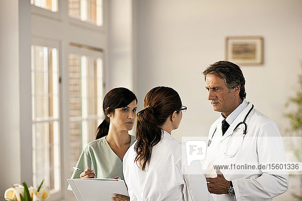 Zwei Ärzte und eine Krankenschwester im Gespräch