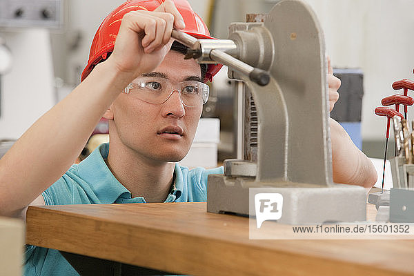 Ingenieurstudent bei der Bedienung einer manuellen Tischpresse mit C-Gestell