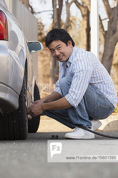 Chinese man putting air in his car tires