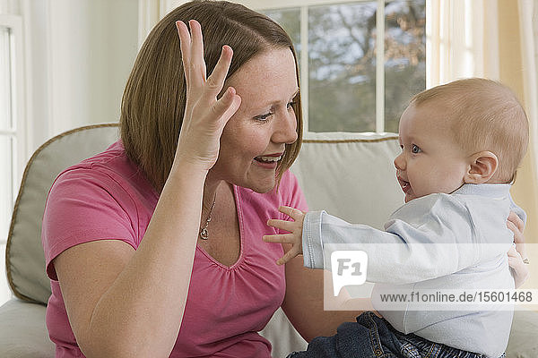 Frau  die das Wort Dad in amerikanischer Zeichensprache gebärdet  während sie mit ihrem Sohn kommuniziert