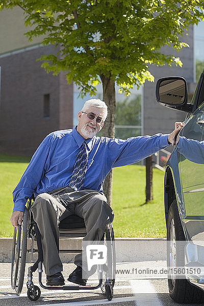 Man with muscular dystrophy and diabetes in a wheelchair beside an accessible van