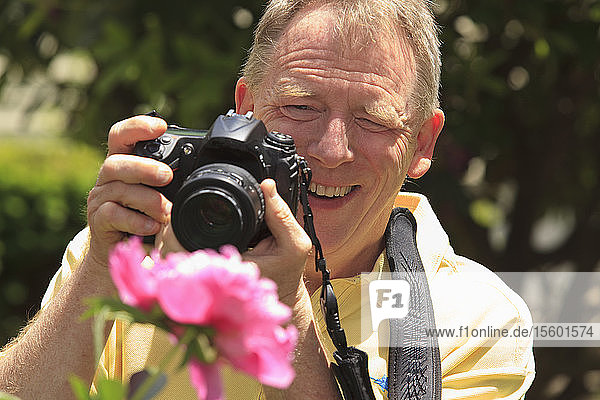 Mann mit zerebraler Lähmung und Legasthenie fotografiert seine Blumen