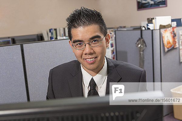 Portrait of happy Asian man with Autism working on computer in an office