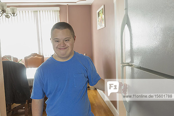 Teen boy with Down Syndrome opening refrigerator