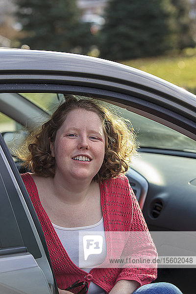 Junge Frau mit Autismus sitzt in ihrem Auto