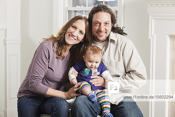 Portrait of a happy couple with their baby at home