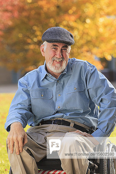 Porträt eines Mannes mit Muskeldystrophie  der in einem Rollstuhl sitzt und lächelt