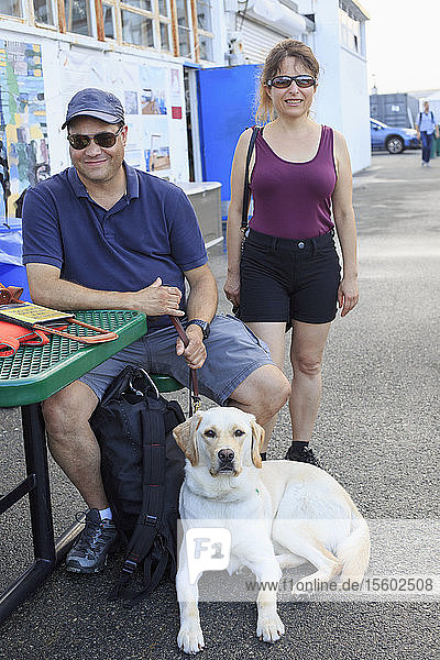 Ein blinder Mann und eine blinde Frau mit einem Diensthund