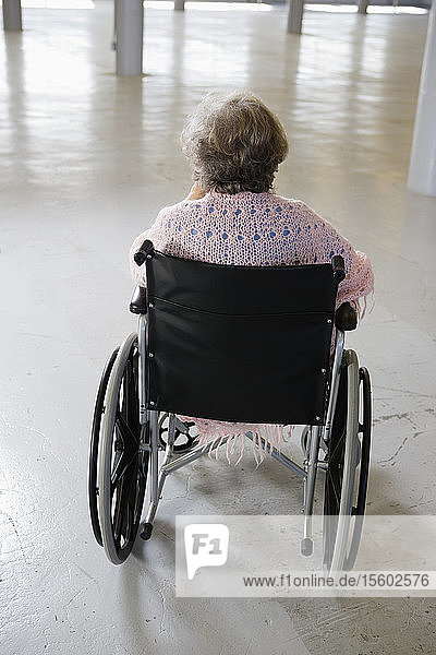 Rückansicht einer alten Frau  die im Rollstuhl sitzt - Inszeniert