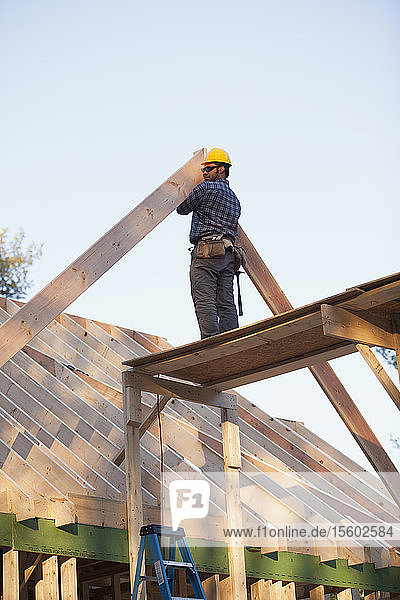 Carpenter placing a rafter