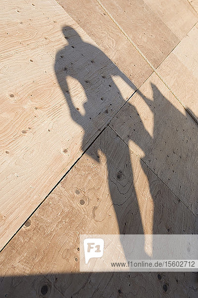 Schatten eines Zimmermanns auf dem Dach eines im Bau befindlichen Hauses