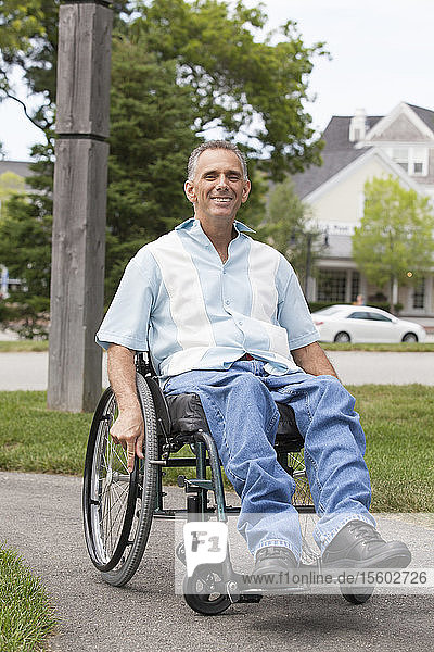 Mann mit Rückenmarksverletzung im Rollstuhl genießt die freie Natur