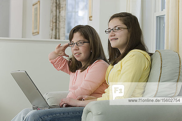Zwei Mädchen im Teenageralter arbeiten an einem Laptop  eines hat einen Geburtsfehler