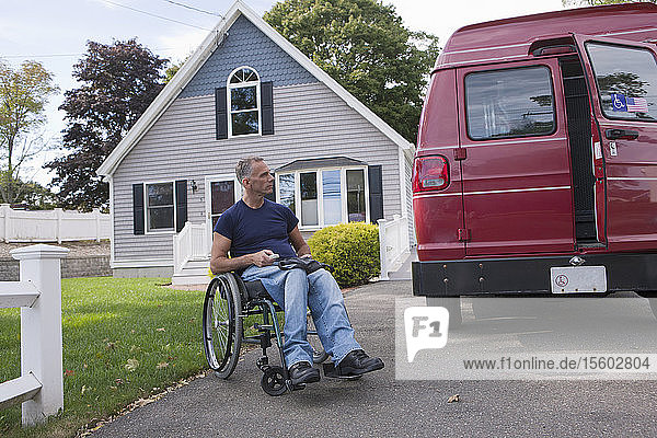 Man with spinal cord injury in a wheelchair getting in his accessible van with a remote