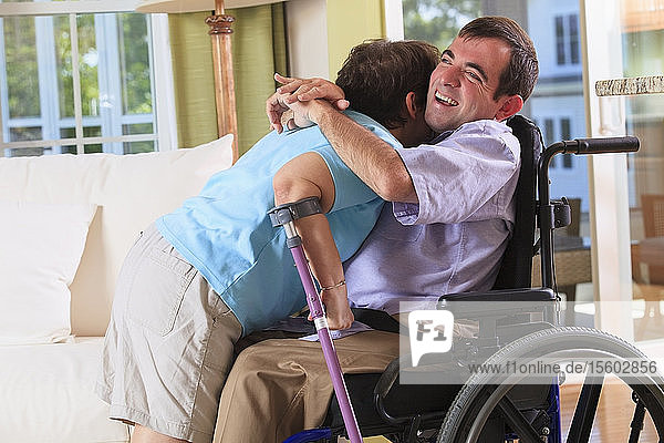 Ehepaar mit zerebraler Lähmung umarmt sich in ihrem Haus