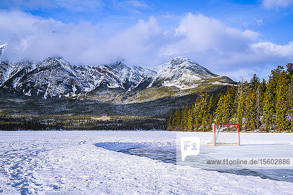 Gefrorener Pyramid Lake mit Eishockeynetz auf einer geräumten Eisfläche im Winter  Jasper National Park; Alberta  Kanada