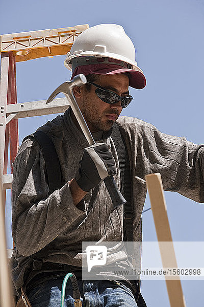 Carpenter hammering wood at a construction site
