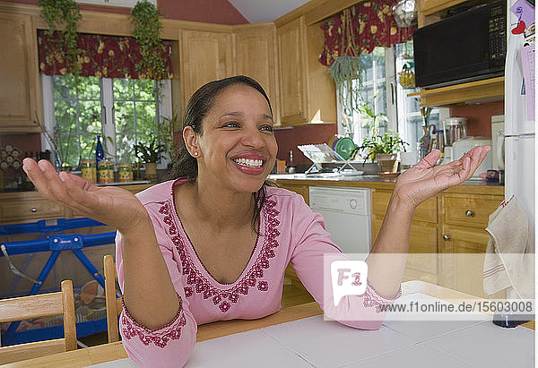 Hispanische Frau lächelnd am Esstisch