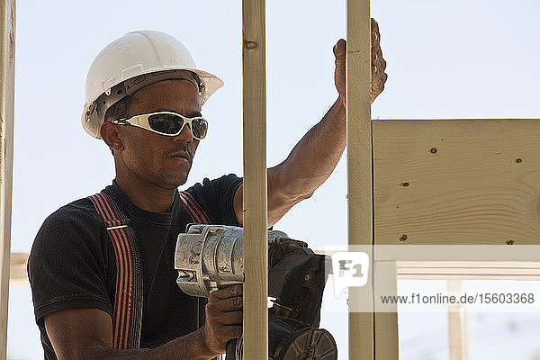 Zimmermann mit einer Nagelpistole auf einer Baustelle