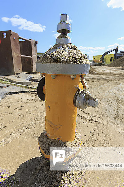 Installation eines Wasserhydranten mit Grabenschild im Hintergrund