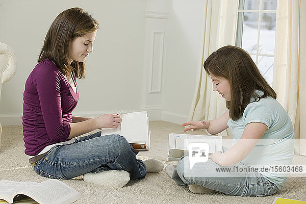 Two teenage girls studying together  one with birth defect