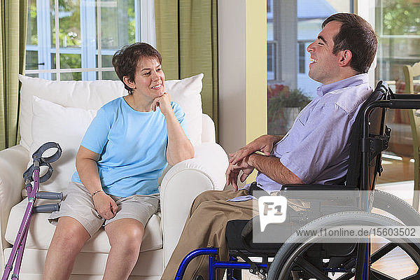 Ehepaar mit zerebraler Lähmung unterhält sich in seinem Haus