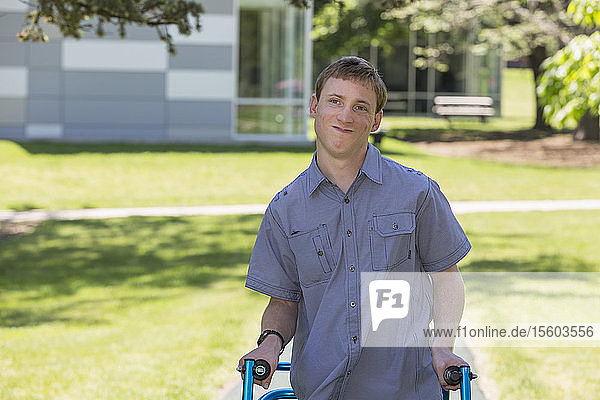 Junger Mann mit Cerebralparese benutzt seinen Rollator  um zur Arbeit zu gehen