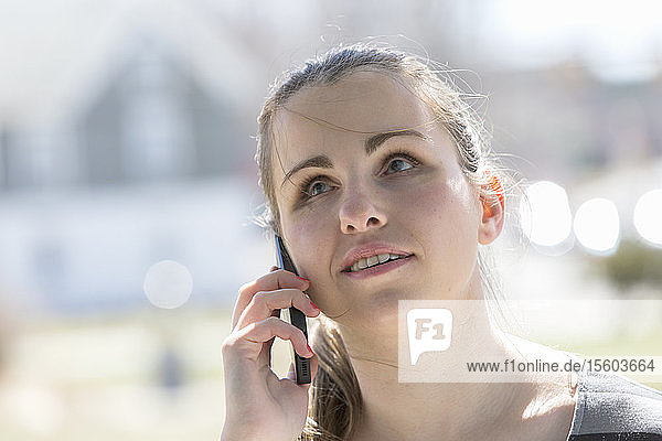 Blinde junge Frau telefoniert mit ihrem Handy