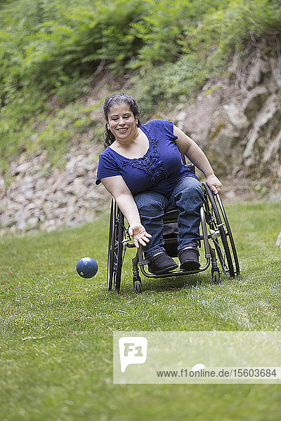 Frau mit Spina Bifida im Rollstuhl spielt Boccia