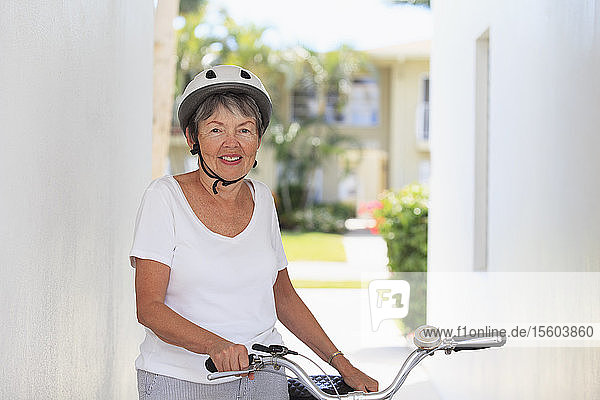 Ältere Frau stehend mit einem Fahrrad