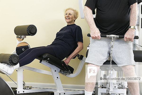 Ein älteres Paar trainiert im Fitnessstudio.