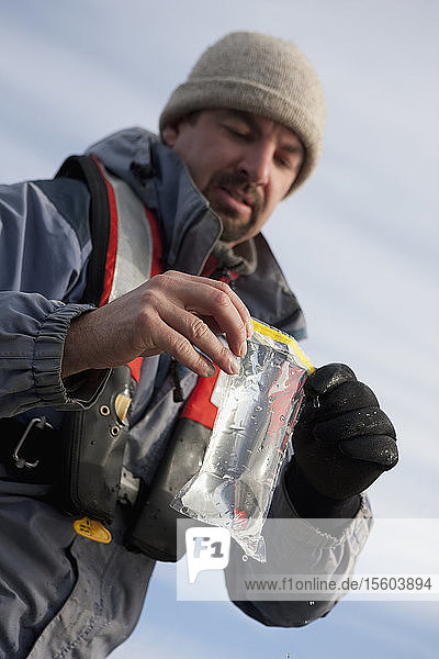 Scientist holding water sample in whirl pak