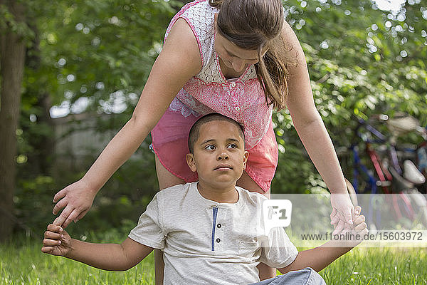 Hispanic boy with Autism playing outside with his sister