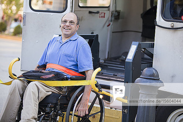 Mann mit Friedreich-Ataxie im Rollstuhl beim Einstieg in ein öffentliches Verkehrsmittel