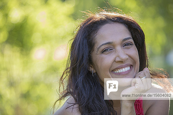 Portrait of happy Hispanic woman smiling in a park