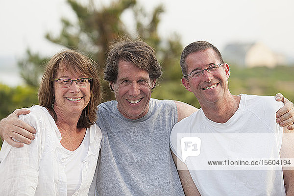 Portrait of a woman smiling with her two brothers