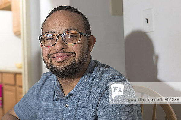 Porträt eines glücklichen afroamerikanischen Mannes mit Down-Syndrom zu Hause