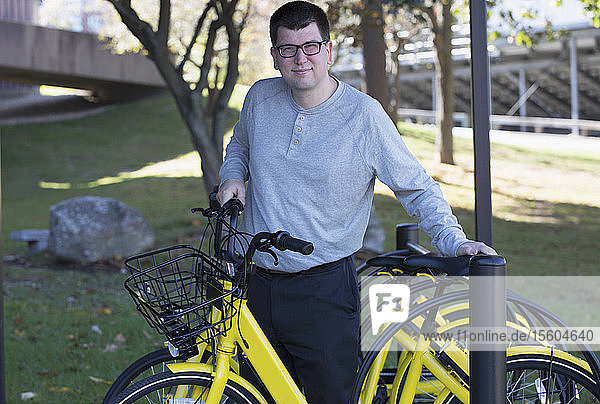 Man with Visual Impairment standing with bike at school