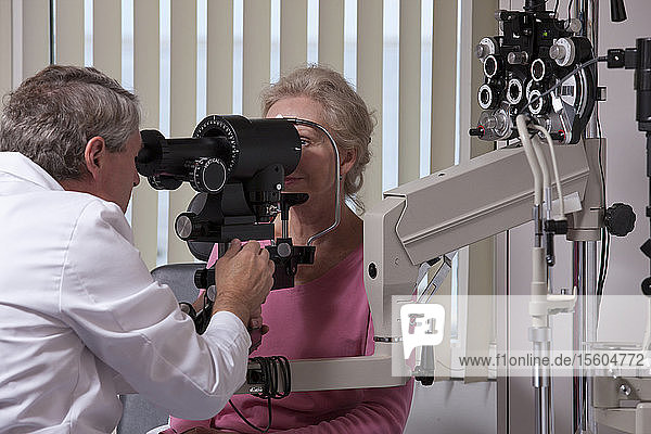 Augenarzt bei der Untersuchung der Augen einer Frau mit einem Keratometer