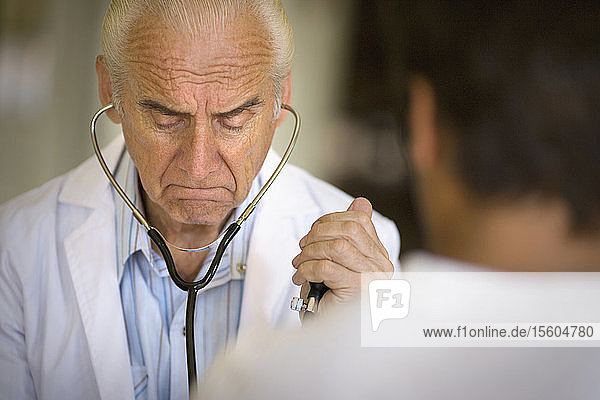 Blick auf einen Arzt  der einen Patienten untersucht.