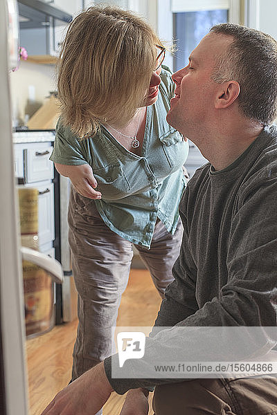 Frau mit TAR-Syndrom und ihr Mann küssen sich zu Hause
