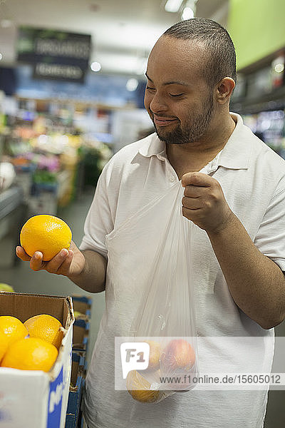 Mann mit Down-Syndrom sammelt Obst in einem Lebensmittelgeschäft